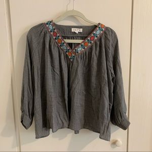 A long sleeve, gray blouse with embroidered collar